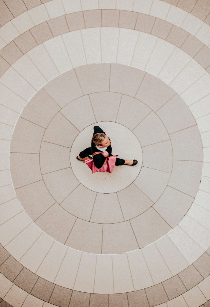 Aerial view of a person walking across a tiled floor with circular patterns