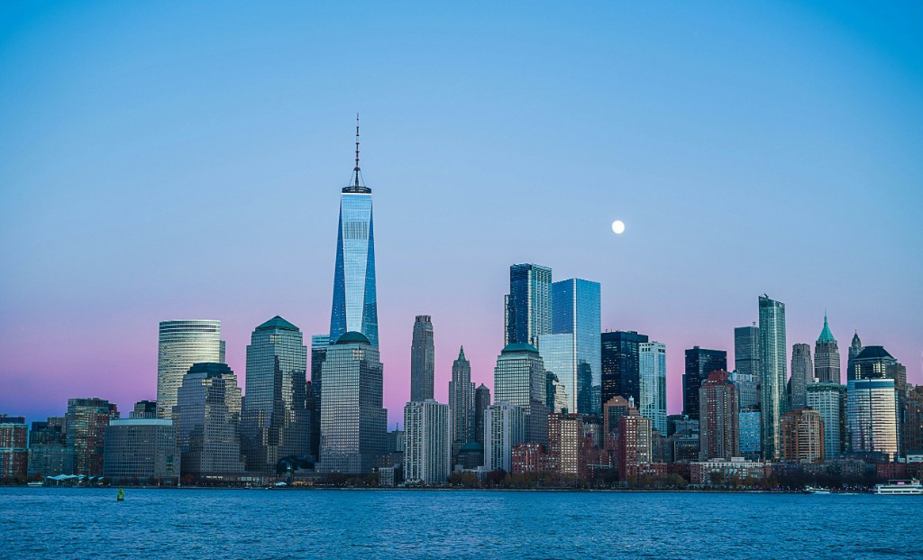 New York City skyline at dusk with One World Trade Center and the Hudson River