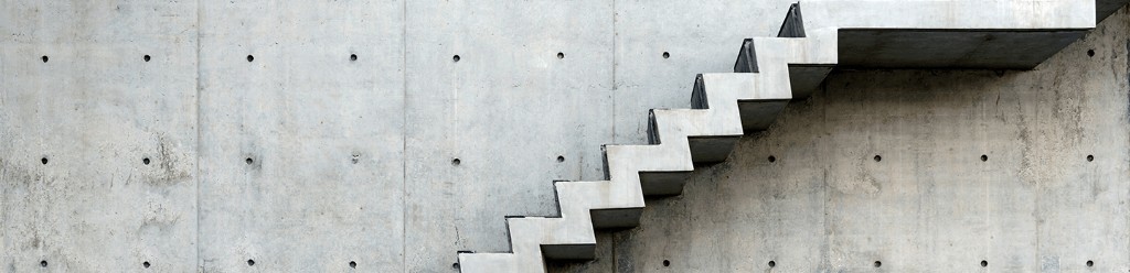 Concrete staircase against a geometric concrete wall