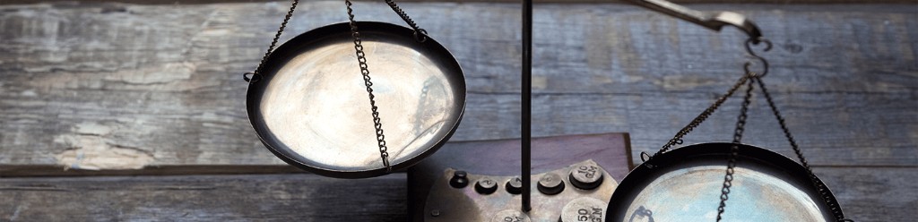 Vintage balance scale on a wooden base against weathered wood