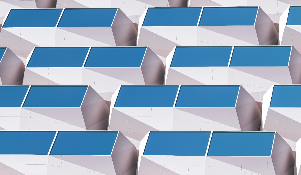 Isometric view of repeating white geometric structures with blue rectangular panels on top